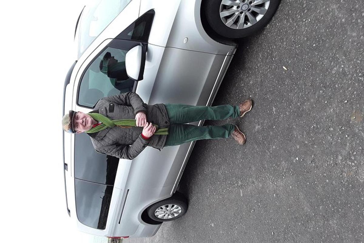 maður situr aftan í bíl