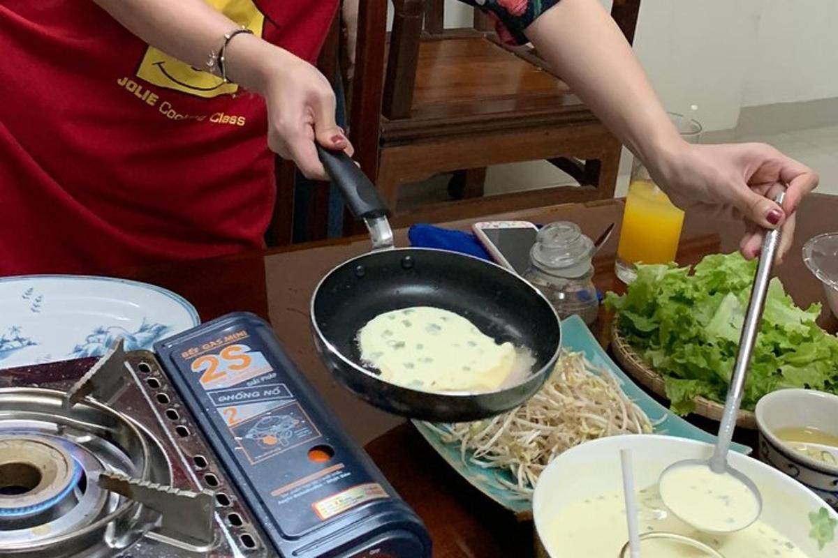 uma pessoa cozinhando comida em uma panela sobre uma mesa