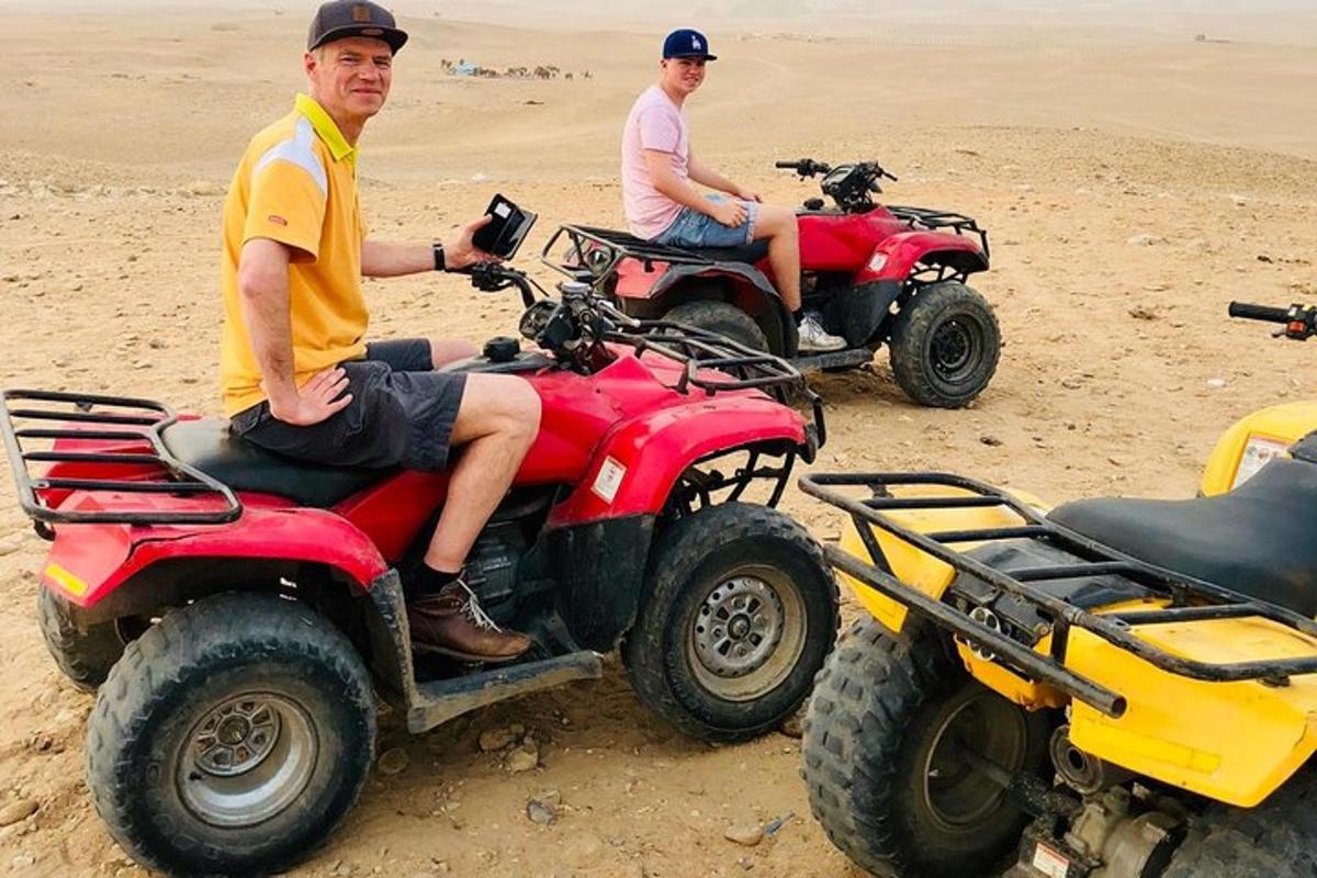 dua pria sedang duduk di atas ATV di padang pasir