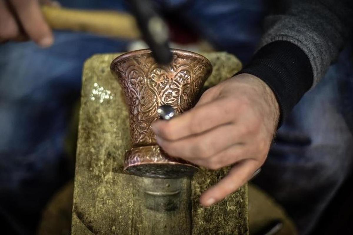 roka, kas tur vāzi ar tajā ievietotu adatu