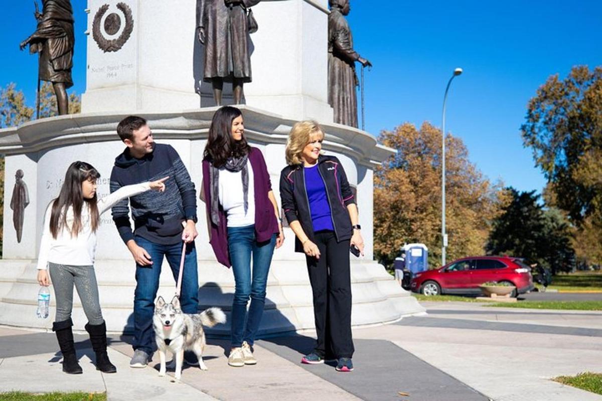 um grupo de pessoas em pé em frente a um monumento com um cachorro
