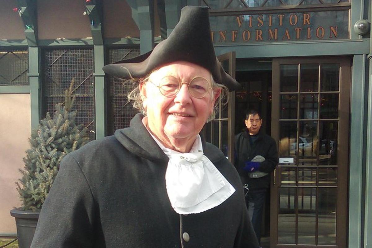 an older woman wearing a witch hat in front of a building
