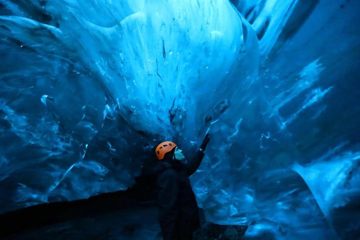 a person standing in front of an ice cave