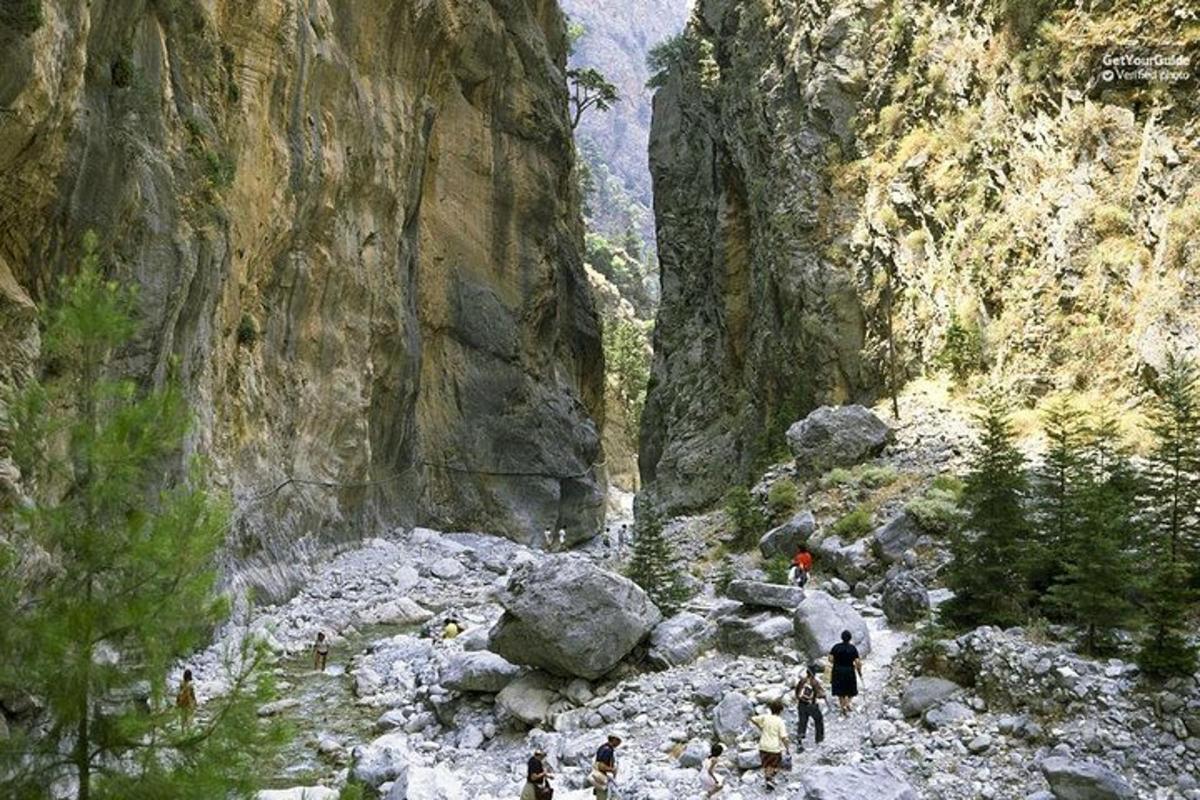 skupina ljudi, ki hodijo skozi skalnati kanjon