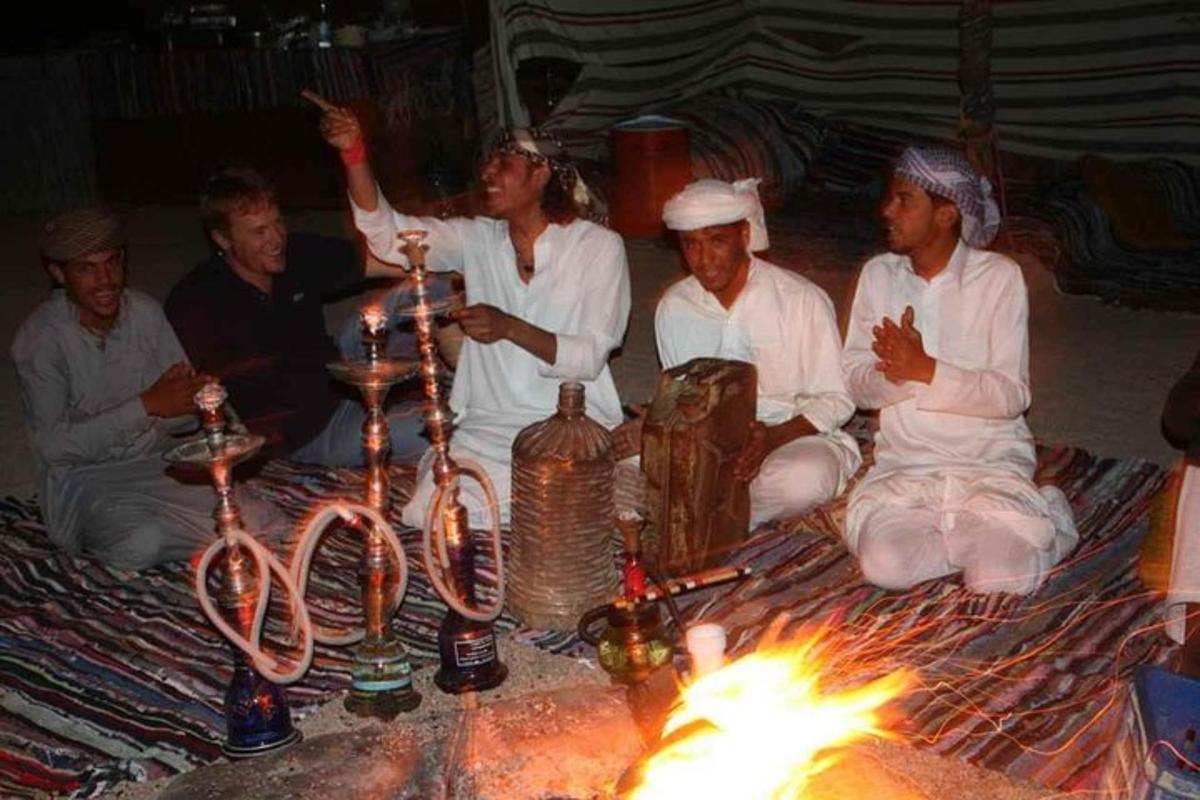 um grupo de pessoas sentadas ao redor de uma mesa com velas