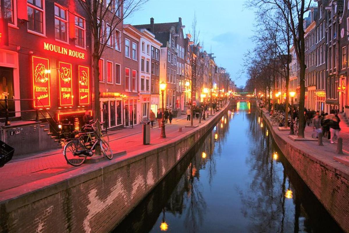um canal em uma cidade à noite com pessoas e edifícios