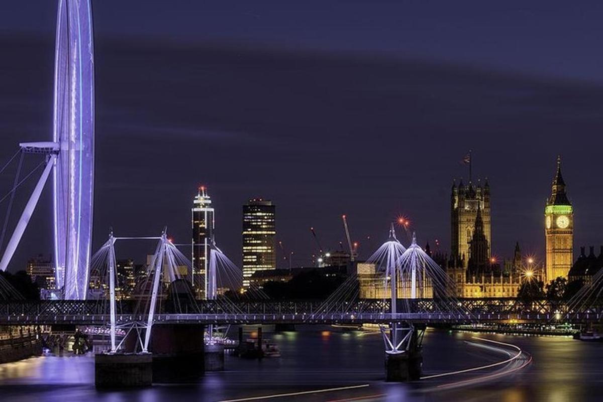 uno skyline della città di notte con un ponte e una torre dell'orologio