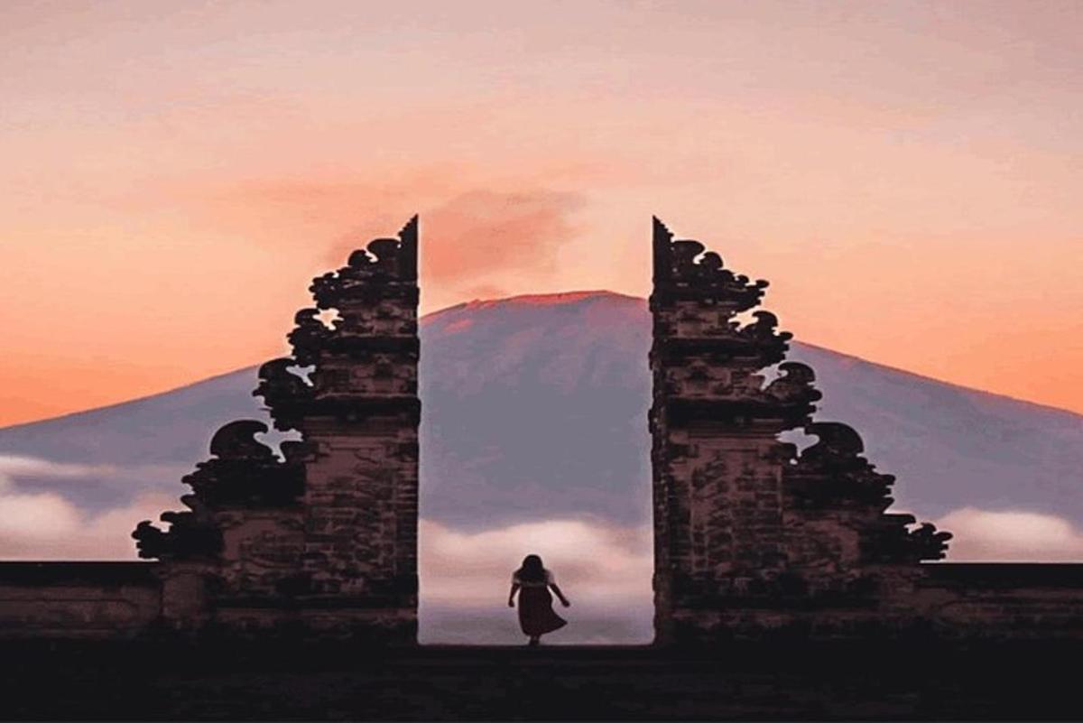 uma mulher parada em frente a um prédio com uma montanha