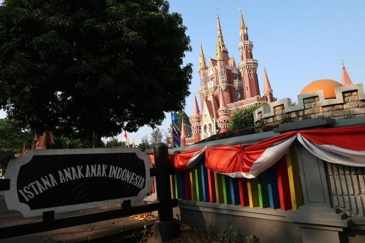 Una valla de arcoíris frente a un castillo de Disney.