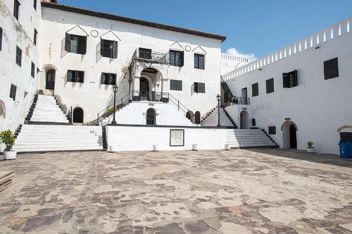 Un gran edificio blanco con escalones y una escalera.