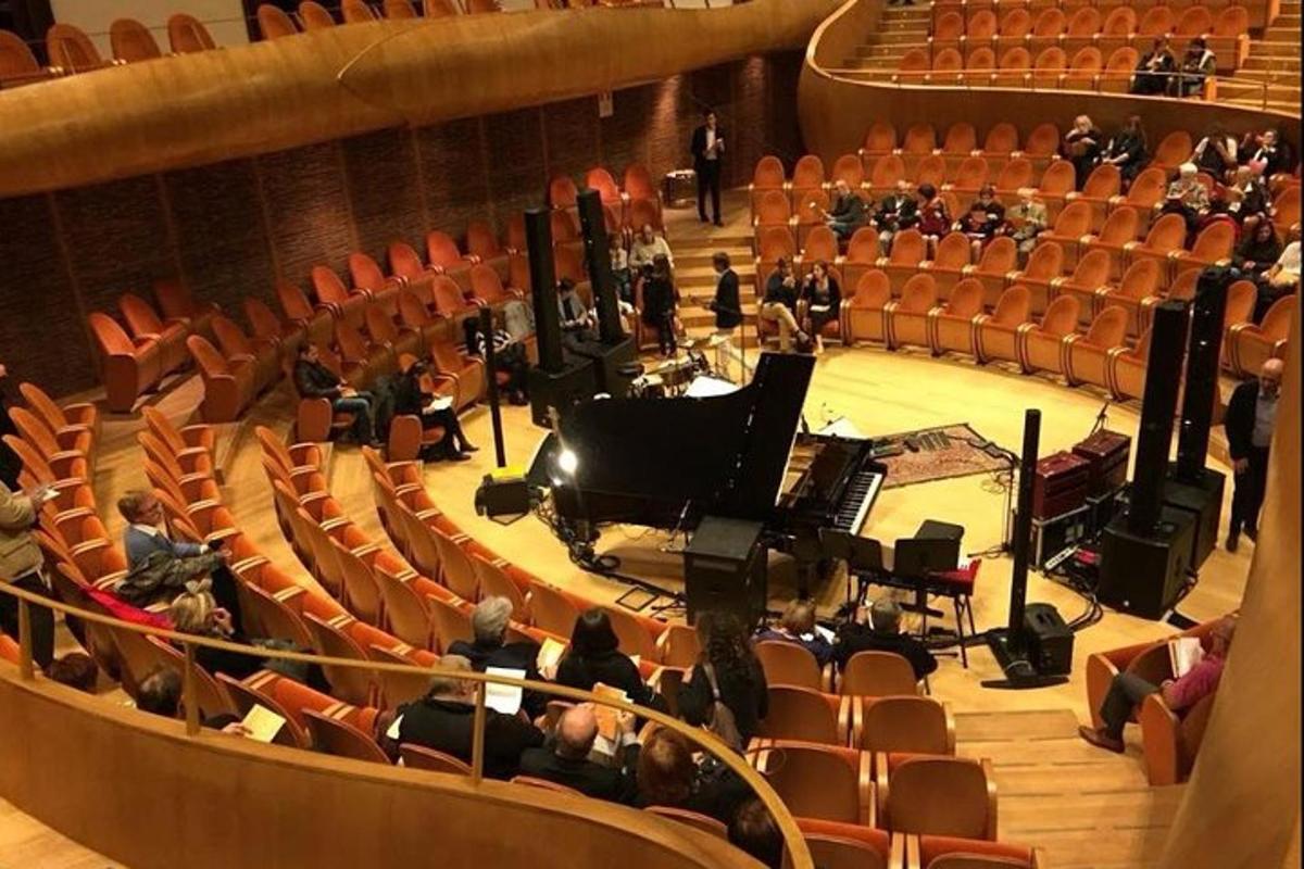 an orchestra in an auditorium with a grand piano
