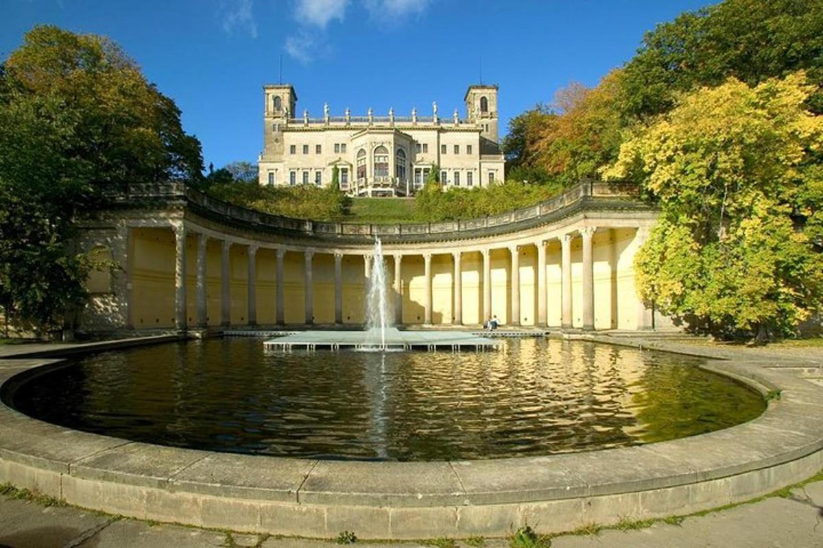 a large building with a fountain in the middle of a pond