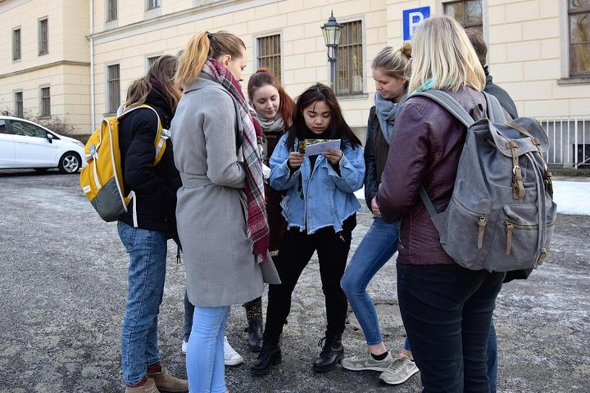 a group of girls standing around looking at a cell phone