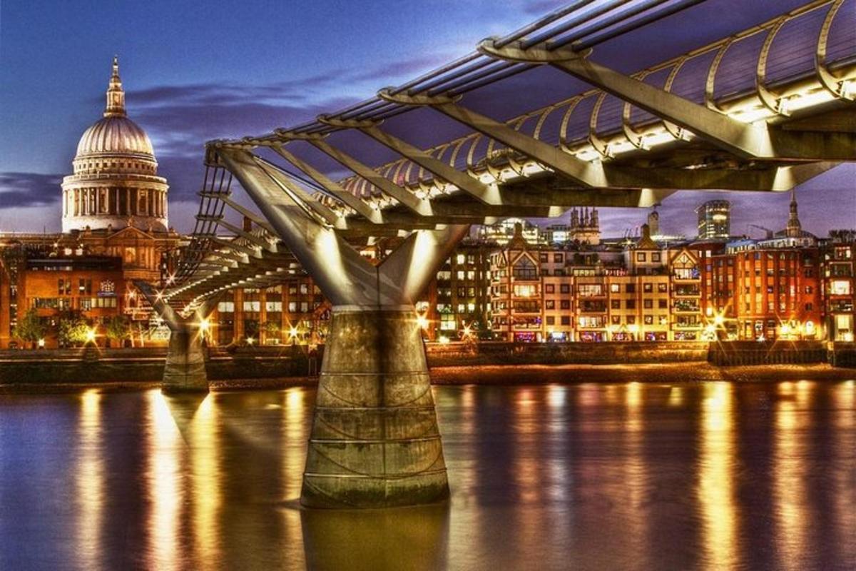 eine Brücke über dem Wasser mit einer Stadt bei Nacht