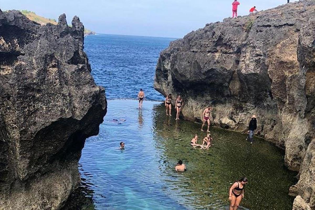 a group of people in the water at a beach