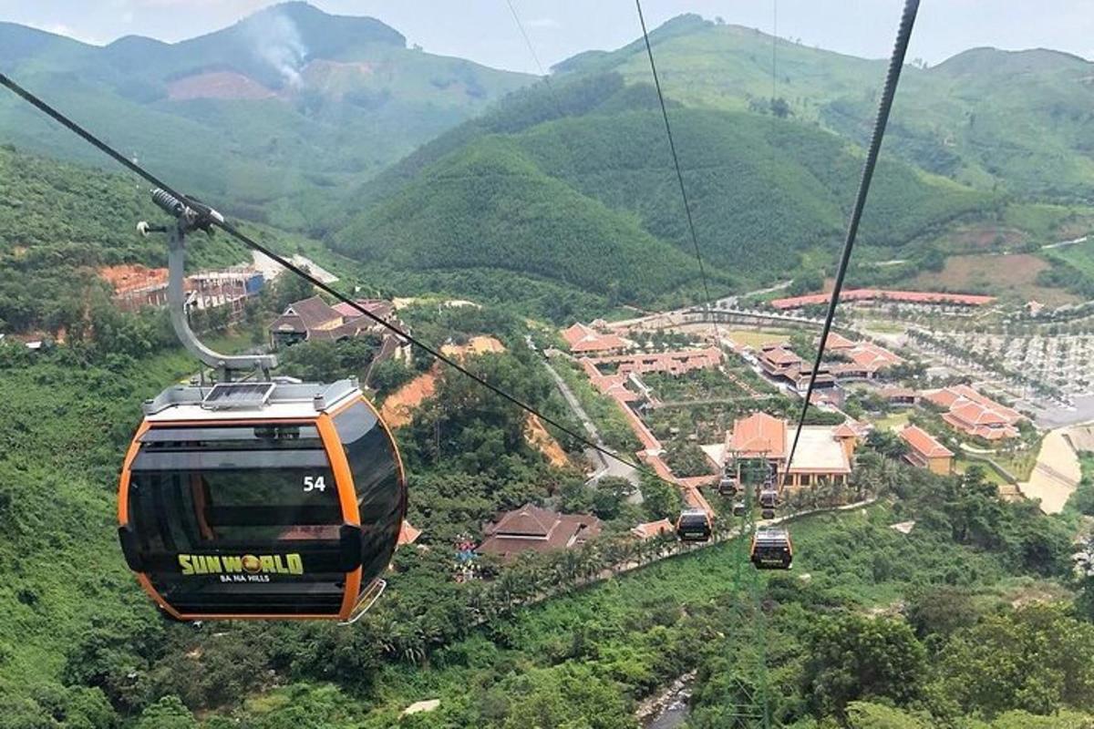 oranžová lanovka letící nad horou