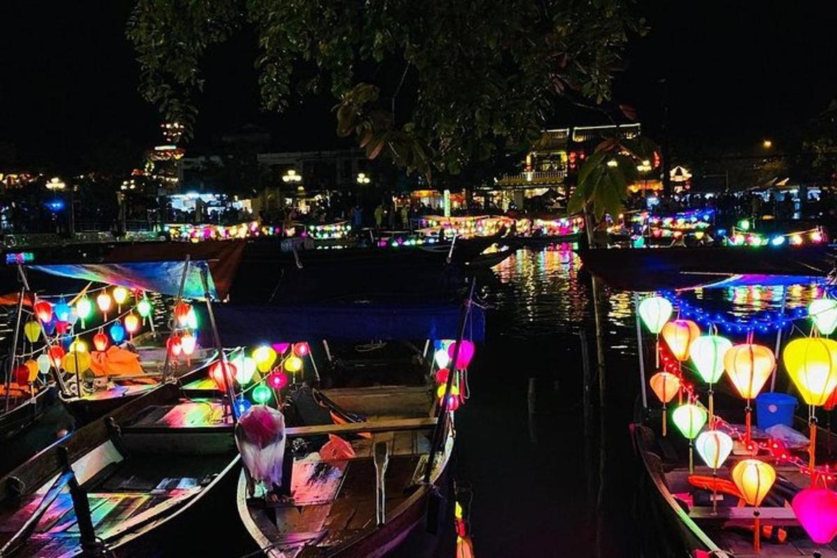 um grupo de barcos com luzes na água à noite