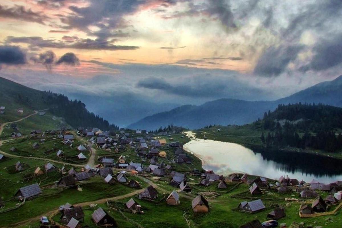 Una vista de un pueblo con un lago y montañas.