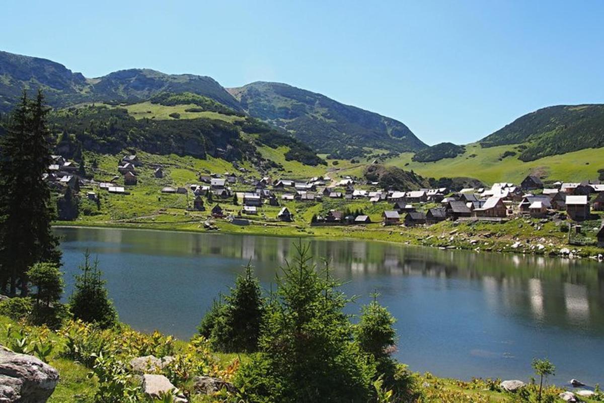un piccolo villaggio in una valle con un lago