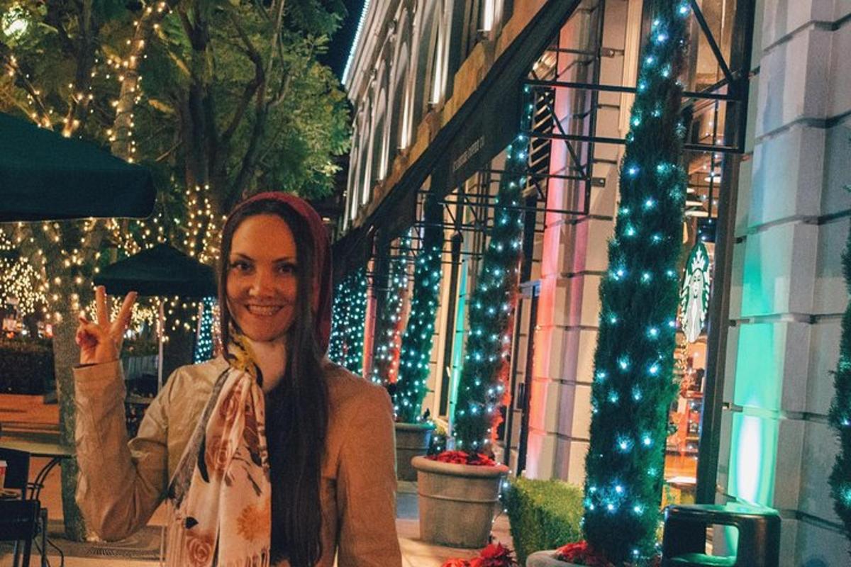 una donna in piedi davanti a un edificio con luci di Natale