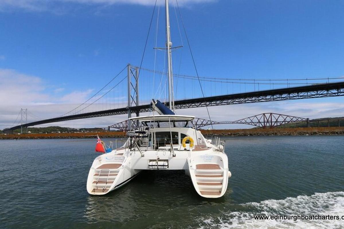 perahu putih di air dengan jembatan di latar belakang