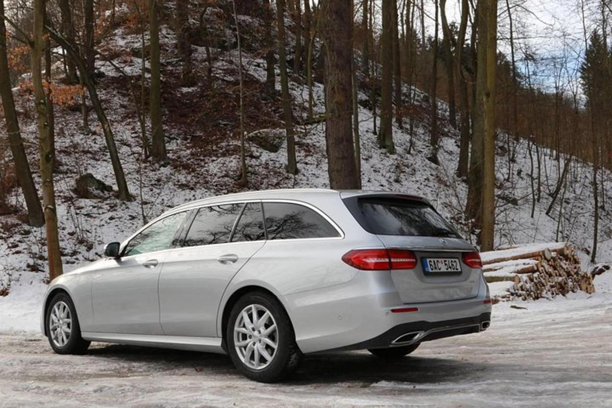 a white car parked in a parking lot in the snow