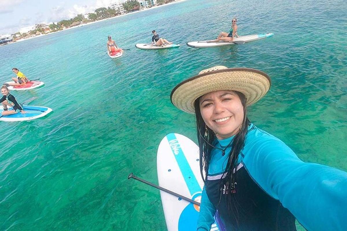 seorang wanita bertopi berdiri di atas papan luncur di dalam air