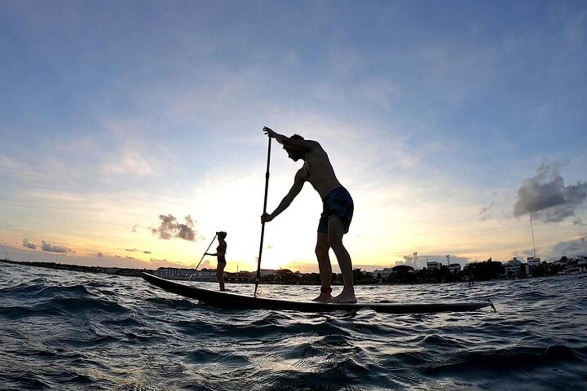 a man standing on a paddle board in the water
