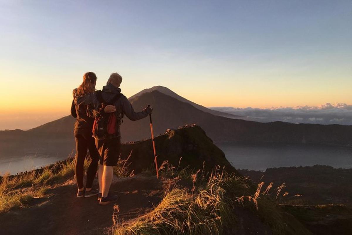 par af fólki stendur uppi á fjallstindi