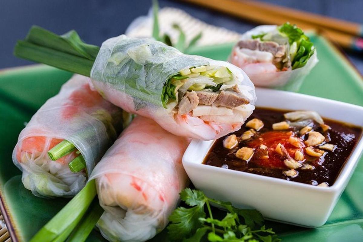 ein Teller mit drei Rollen Sushi und einer Schüssel Soße