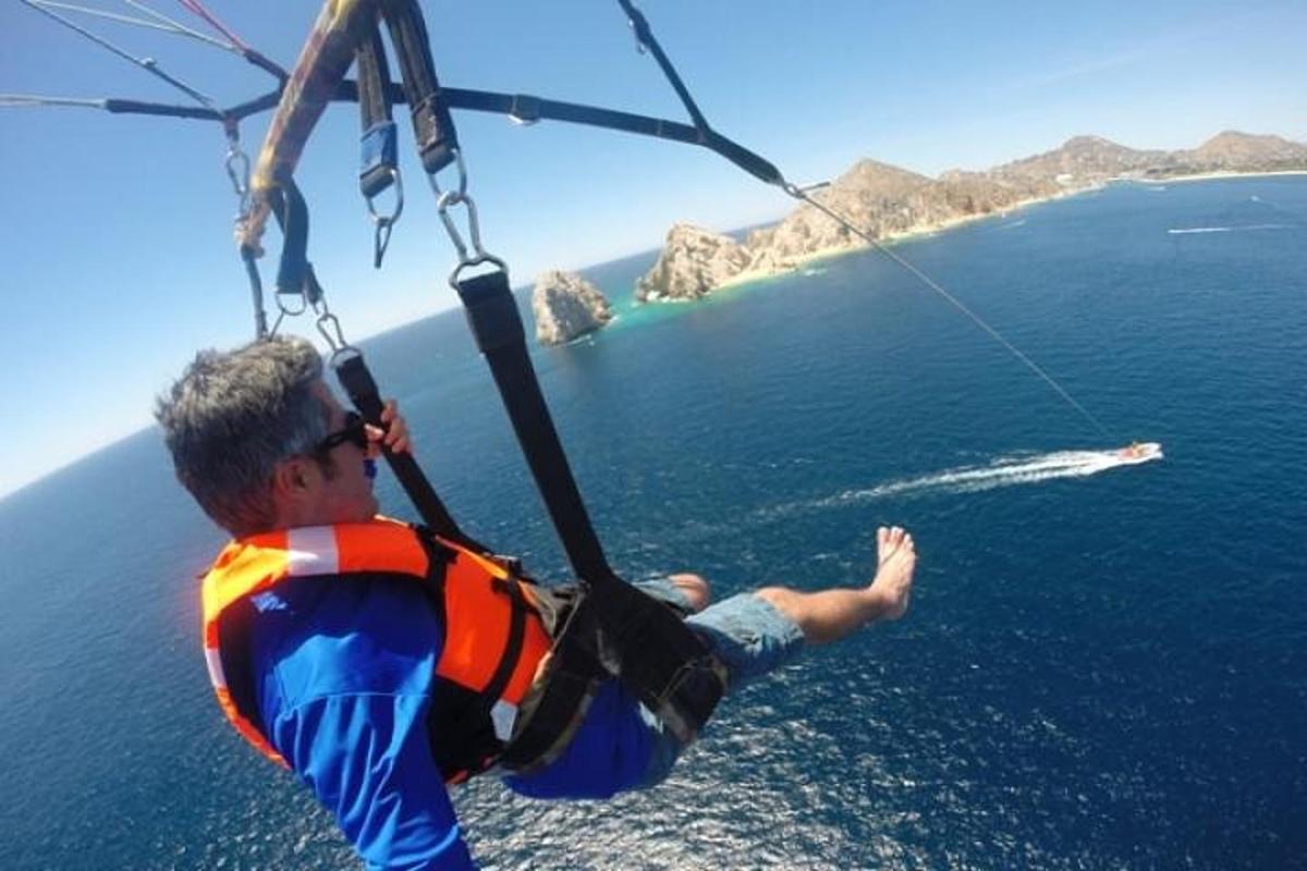 Ένας άντρας με σωσίβιο κρέμεται από αλεξίπτωτο πάνω από τον ωκεανό