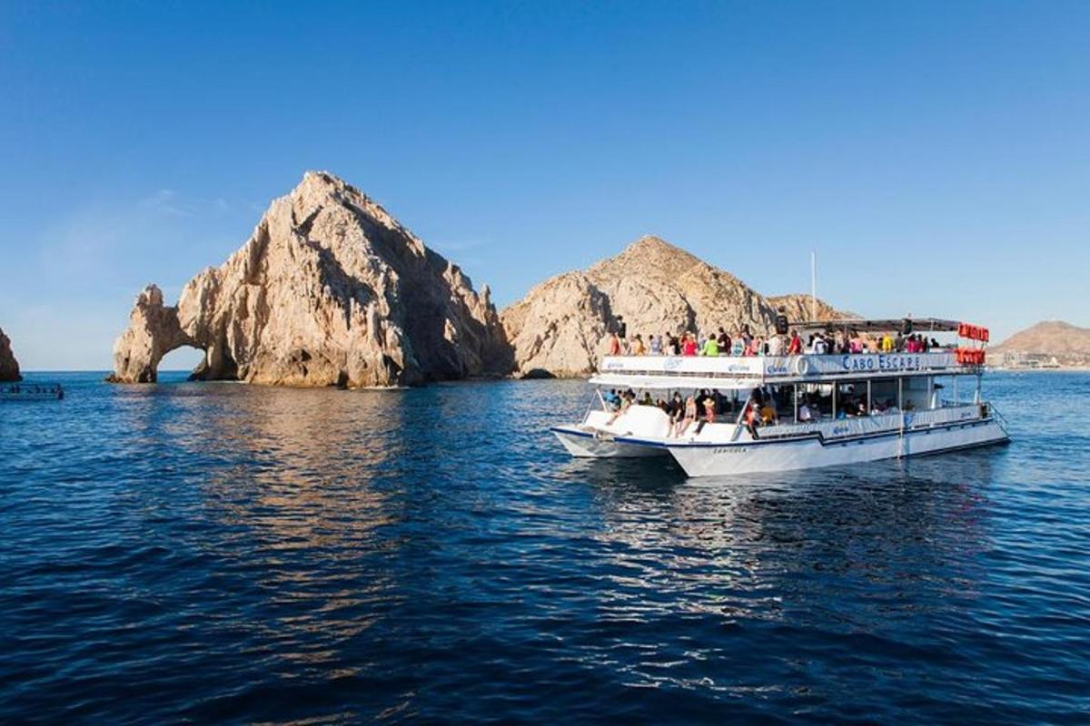 Un barco lleno de gente en el agua con rocas.