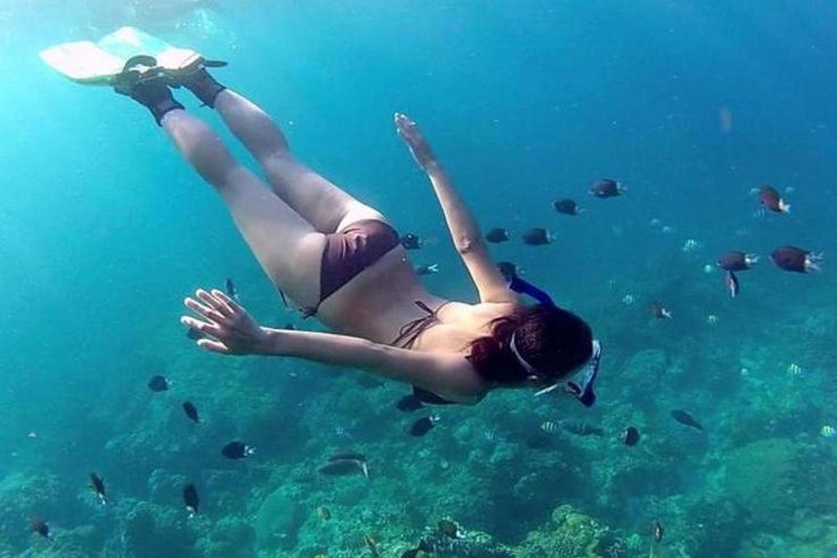 una donna sdraiata nell'acqua con un libro