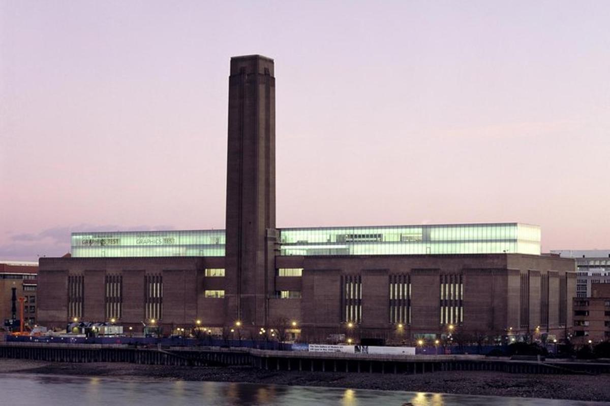 un grande edificio con una torre dell'orologio accanto a un fiume