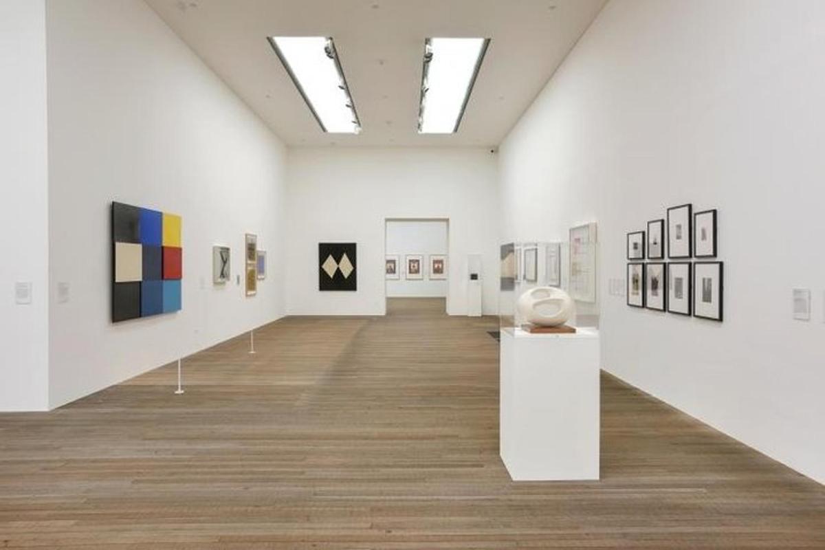 una stanza con dipinti e fotografie esposti in un museo