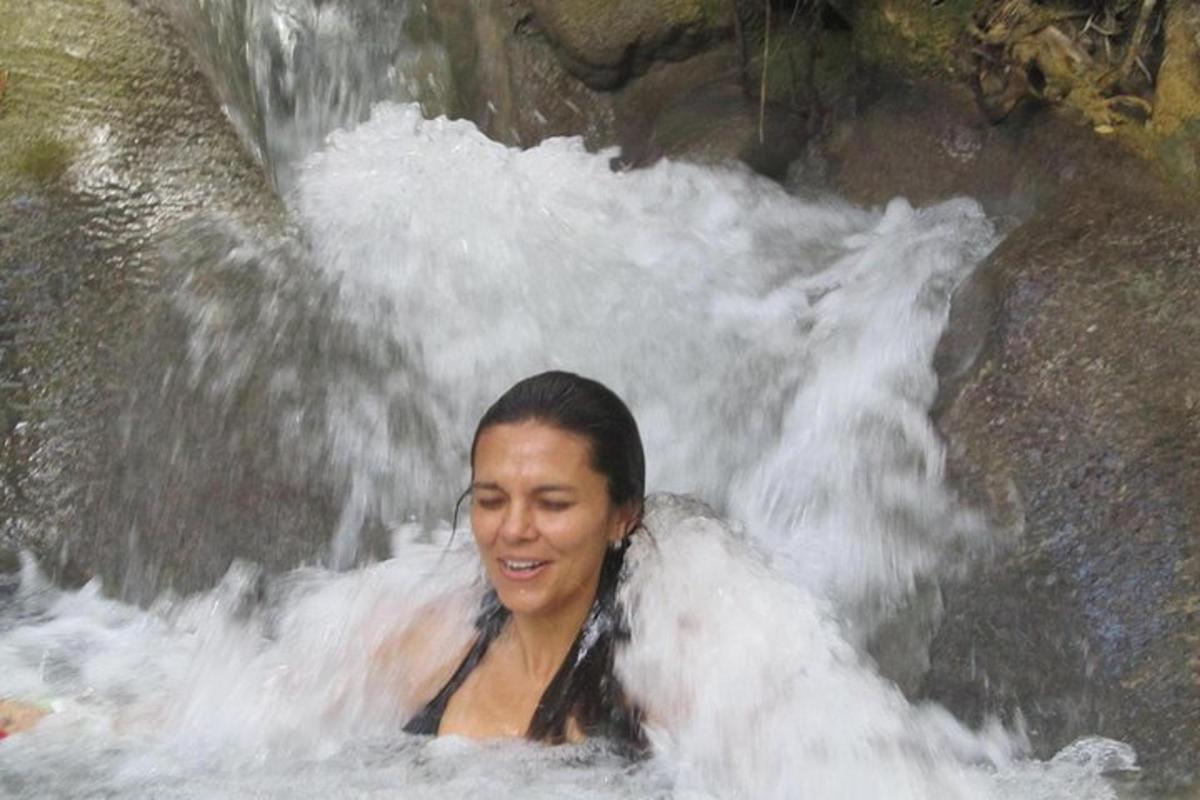 une femme est dans une cascade dans l'eau