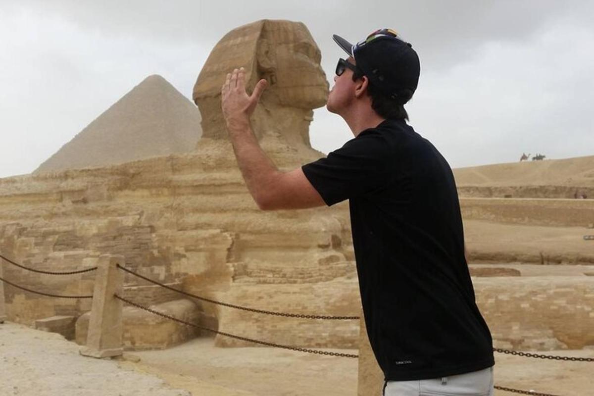 muž fotografující sfingu a pyramidu