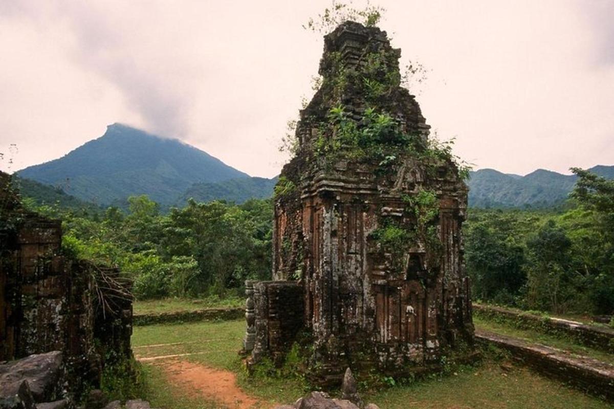 uma antiga estrutura de pedra em um campo com montanhas ao fundo