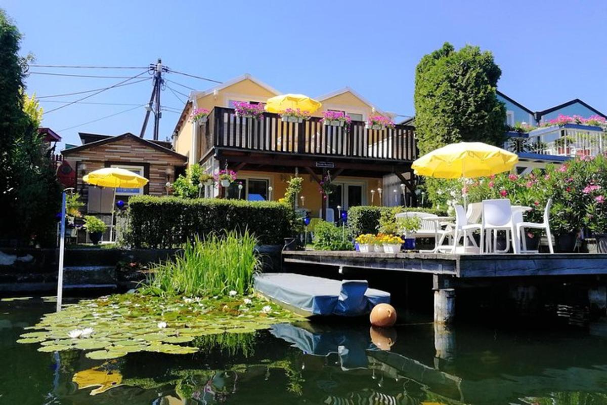 uma casa com um lago com cadeiras e guarda-sóis