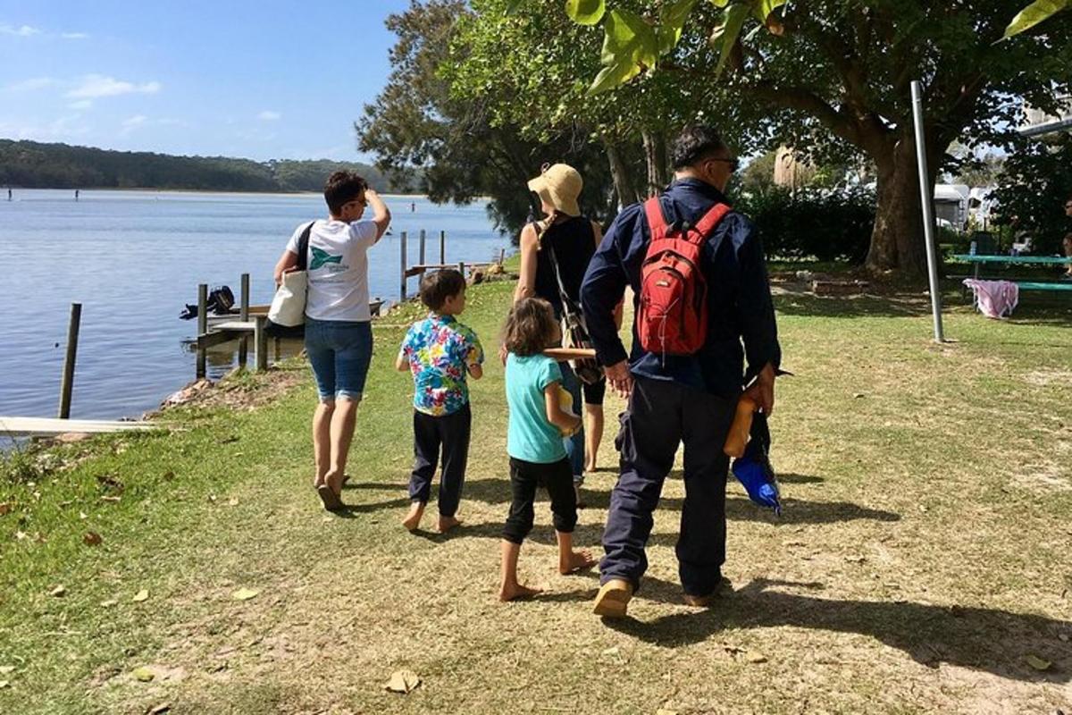 a group of people walking by the water