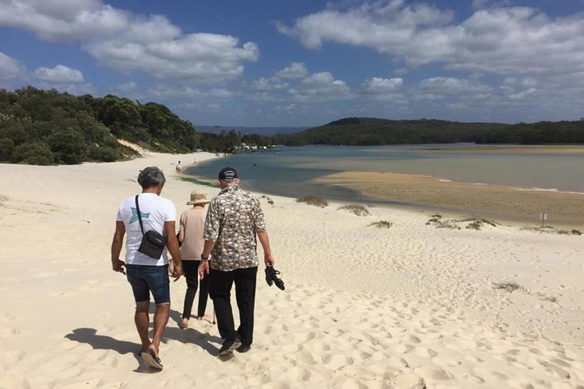 a group of three people walking on a beach