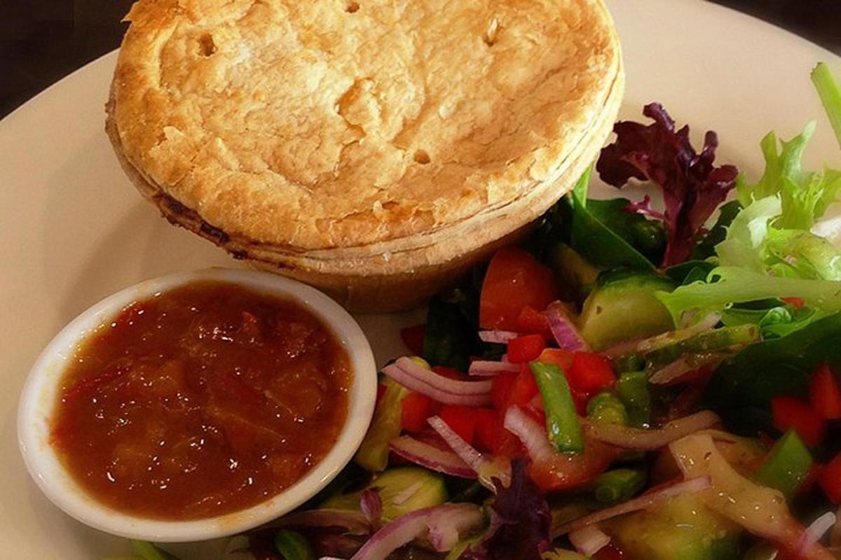 um prato com uma salada e um sanduíche e molho para mergulhar