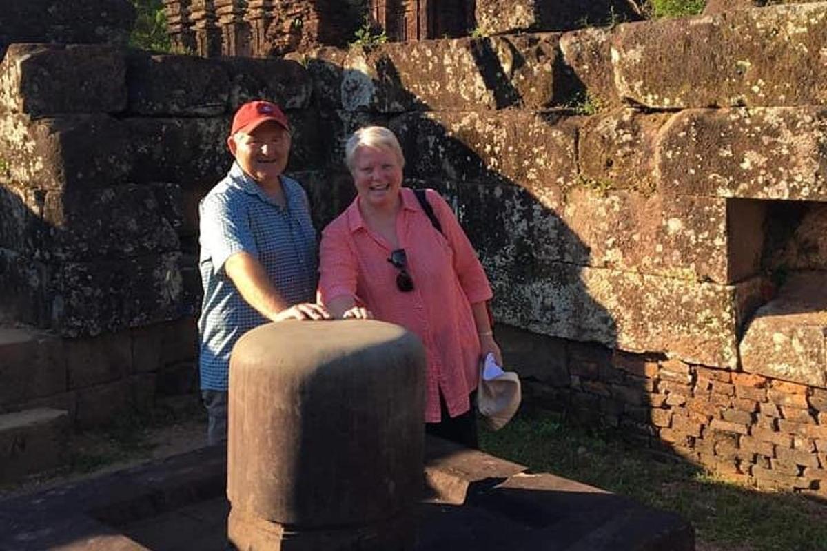 a man and a woman standing next to a stone pillar