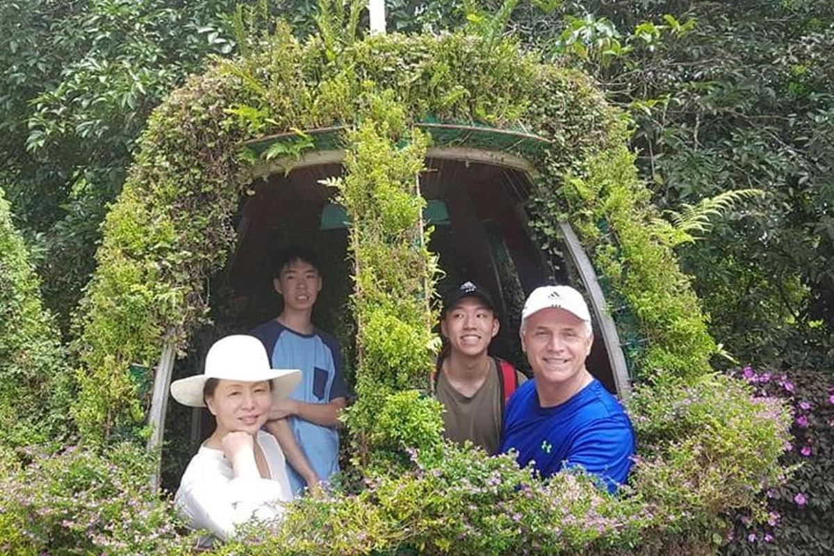 a group of people standing in a tunnel of plants