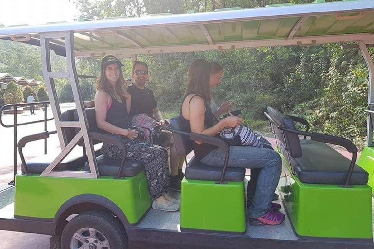 skupina lidí sedících v golfovém vozíku