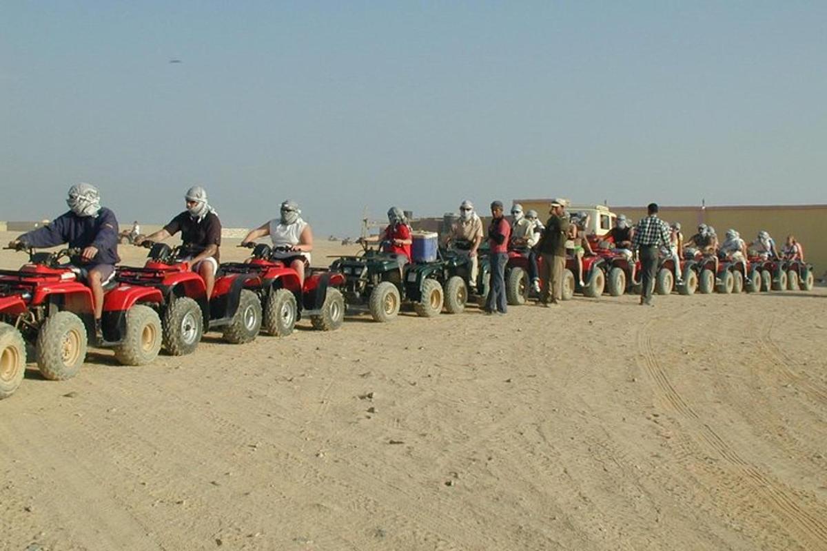 Un grupo de personas en vehículos todo terreno en el desierto.