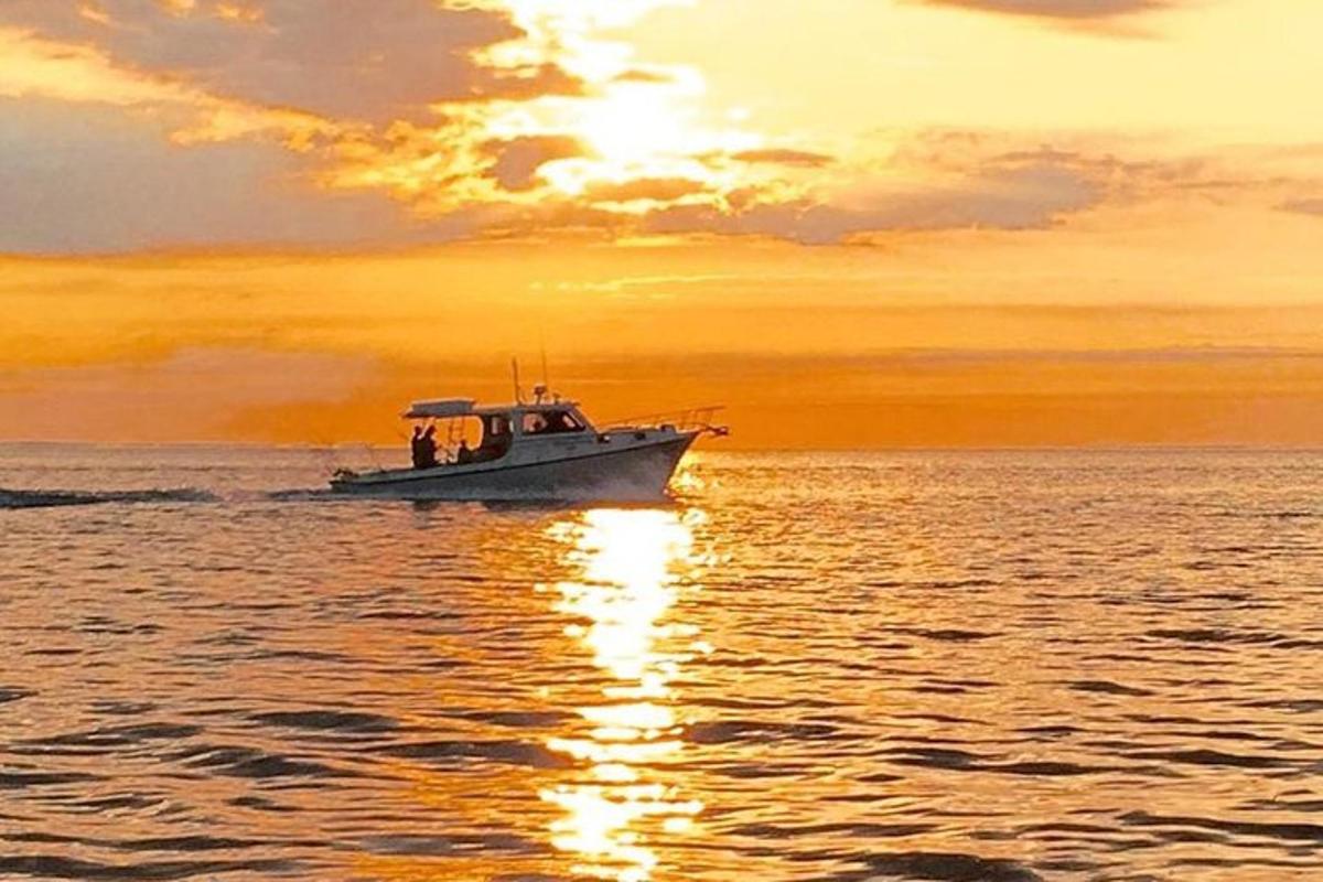 una barca sull'acqua con un tramonto sullo sfondo