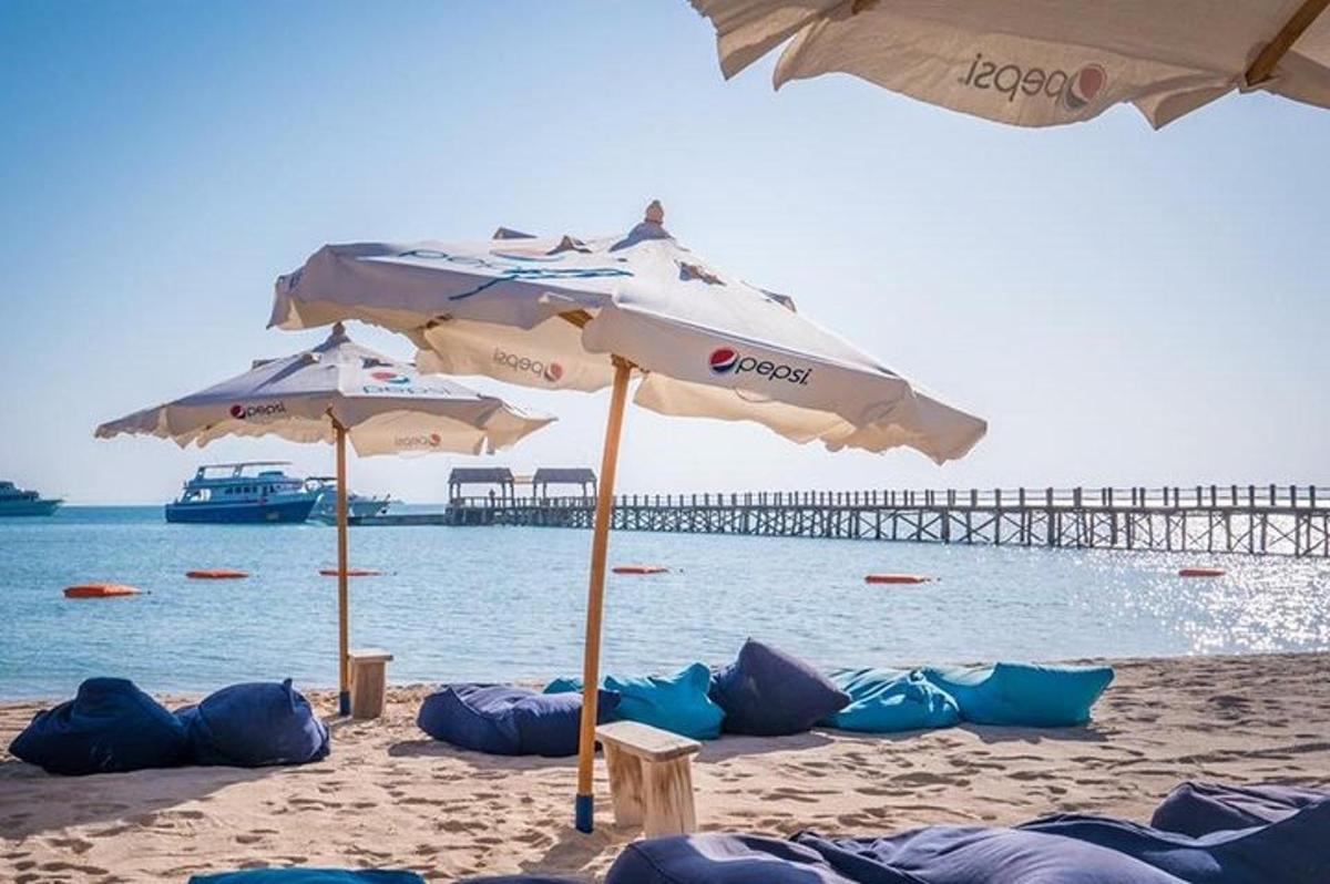 una playa con dos sombrillas y un muelle