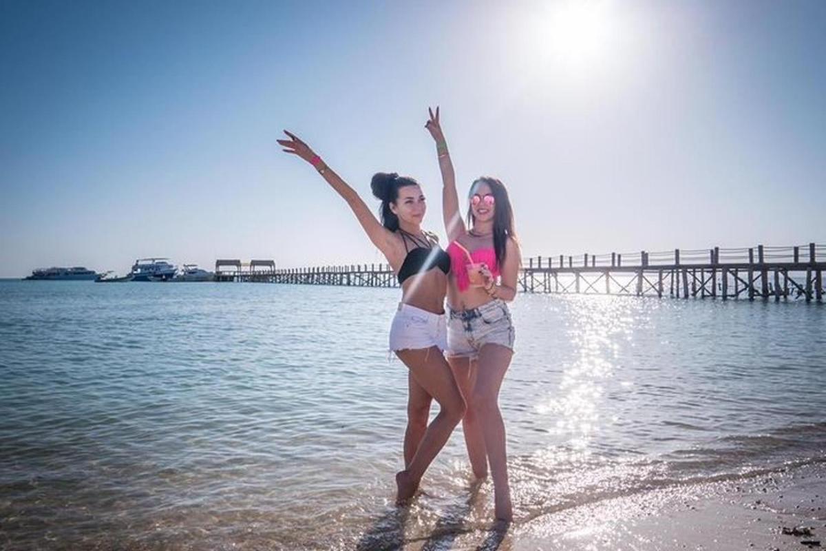 Dos mujeres paradas en el agua en la playa