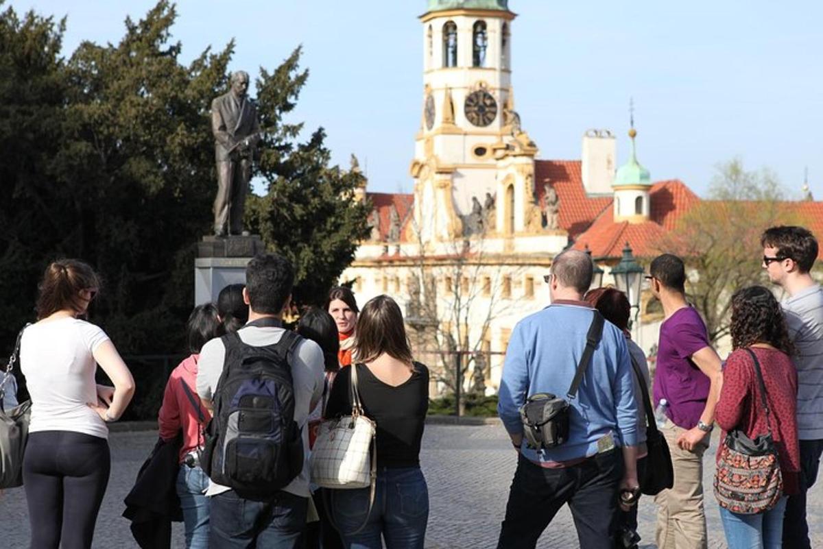 μια ομάδα ανθρώπων που στέκονται μπροστά από ένα κτίριο με έναν πύργο ρολογιού